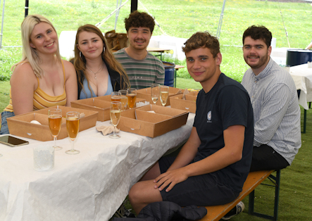 students sat at a table with drinks and picnic